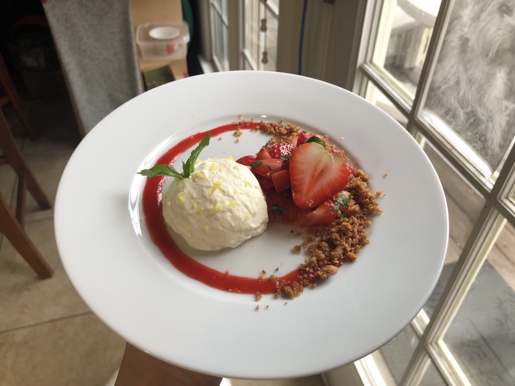 Fancy lemon mousse with macerated strawberries, strawberry coulis, and graham crumble